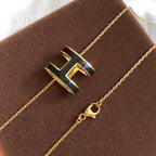 Aura HM CLIC BLACK ENAMEL GOLD NECKLACE